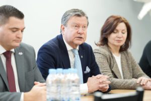Pašvaldība turpinās uzlabošanas darbus Rīgas Hokeja skolas ēkās - Trīs cilvēki formālā apģērbā sēž pie galda