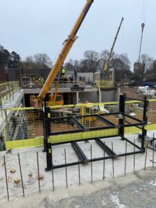 Būvlaukums ar celtni, veidņu konstrukcijām un dzelzsbetona elementu montāžas darbiem ēkas stāvā