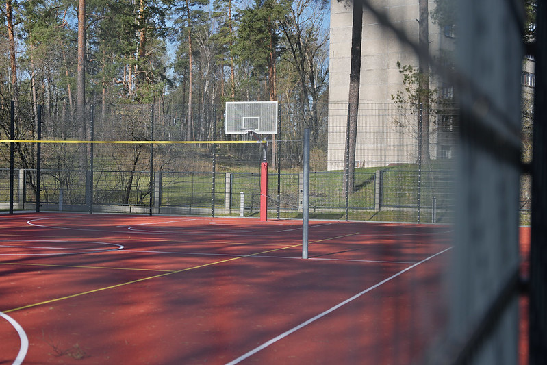Sporta laukums ar basketbola grozu un segumu āra aktivitātēm.