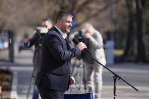 Persona runā pie mikrofona āra pasākumā.