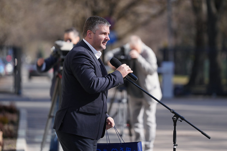 Persona runā pie mikrofona āra pasākumā.