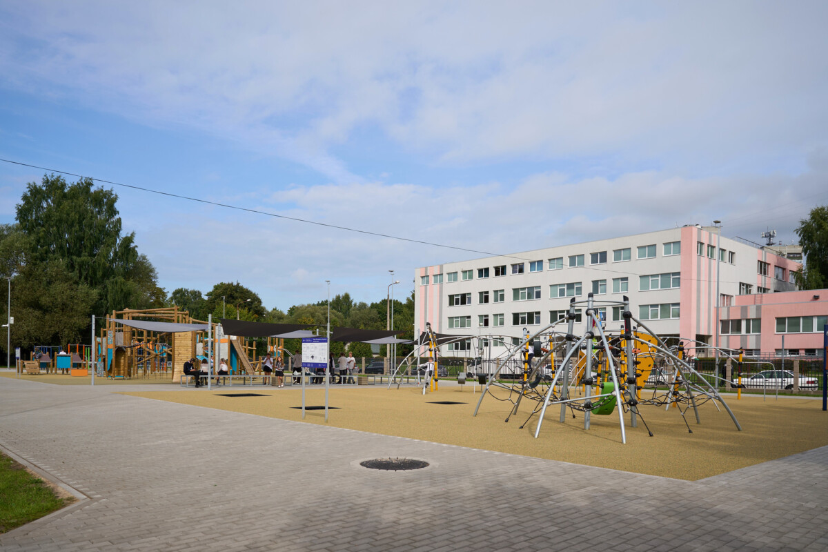 Rīgas Ziepniekkalna vidusskolas teritorijā izveidots plašs aktīvās atpūtas laukums ar rotaļu un kāpšanas konstrukcijām. Fonā redzama skolas ēka un apmeklētāji
